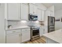 Well-appointed kitchen with stainless steel appliances, white cabinets and beautiful countertops at 9577 Sandy Bluffs Cir, Parrish, FL 34219