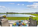 Outdoor patio seating area overlooking a scenic lake view, ideal for relaxing and entertaining guests at 9577 Sandy Bluffs Cir, Parrish, FL 34219