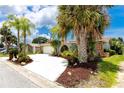 Beautiful single-story home with lush landscaping, a red tile roof, stone accents, and a spacious driveway at 9909 San Mateo Way, Port Richey, FL 34668