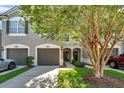 Charming townhome featuring a two-car garage, a well-maintained lawn and a decorative door at 10217 Westpark Preserve Blvd, Tampa, FL 33625