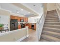 Bright open kitchen adjacent to carpeted staircase, featuring modern appliances and tile flooring at 10217 Westpark Preserve Blvd, Tampa, FL 33625