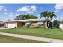 Well-maintained single-story home with lush landscaping, brick accents, and a two-car garage at 10387 Majestic Dr, Largo, FL 33774