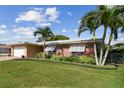 Beautiful single-story home with a green lawn, brick accents, and a two-car garage at 10387 Majestic Dr, Largo, FL 33774