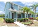 Charming two-story blue townhome featuring a well-maintained lawn with young palm trees at 11617 Colony Lake Dr, Tampa, FL 33635