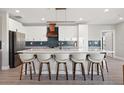 Modern kitchen featuring a large island with seating, stylish backsplash, and stainless steel appliances at 12400 Capri N Cir, Treasure Island, FL 33706