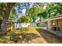 Spacious backyard featuring mature trees, storage shed, and an outdoor swing, ideal for Gathering fun at 1403 W Pradera Ave, Tampa, FL 33612