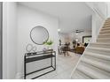Open-concept entryway boasts a modern black console table, mirror, and staircase leading to the upper level at 3004 Conifer Dr, Largo, FL 33771