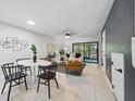 Open-concept living room, dining space showcasing a modern table set, and access to the backyard at 3004 Conifer Dr, Largo, FL 33771