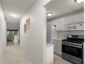 View of a well-lit hallway with tile flooring leading to the living area and a partial view of the kitchen at 3114 59Th S St # 203, Gulfport, FL 33707