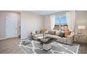 Bright living room with neutral paint, large windows and a decorative rug at 35665 Lockman Way, Zephyrhills, FL 33541