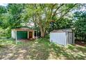 View of the property's detached garage, a storage shed, and surrounding trees at 38839 Miller Ave, Zephyrhills, FL 33542