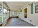 Screened porch with concrete flooring, white trim, and a view of the front yard at 38839 Miller Ave, Zephyrhills, FL 33542