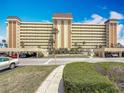 Exterior front view of condo complex with lush landscaping, convenient parking, and architectural details at 4725 Cove Circle # 908, St Petersburg, FL 33708