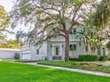 Charming two-story home with a brick exterior, lush green lawn, and mature trees creating a picturesque setting at 504 Riverside Dr # 504, Tarpon Springs, FL 34689