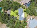 An aerial view shows the house surrounded by lush greenery and mature trees in a residential area at 601 75Th St N, St Petersburg, FL 33710