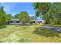 Inviting single-story home with mature trees, a brick chimney, and a classic driveway and manicured lawn at 601 75Th St N, St Petersburg, FL 33710