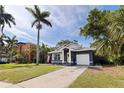 Charming single-story home featuring a large palm tree, well-manicured lawn, and inviting yellow front door at 642 14Th S Ave, St Petersburg, FL 33701