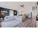 Spacious living room with a large sofa, ceiling fan, stainless steel refrigerator, and an open-concept kitchen at 642 14Th S Ave, St Petersburg, FL 33701
