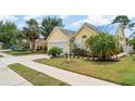 Inviting yellow home with lush landscaping and a spacious driveway, nestled in a friendly neighborhood at 7833 Ontario Street Cir, Sarasota, FL 34243