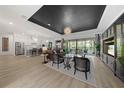 Spacious open-concept living room with modern lighting, black ceiling accent, and a view to outdoor living at 7922 Lakes Edge Ln, Port Charlotte, FL 33981