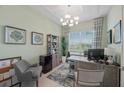 Cozy home office featuring a large window, stylish decor, and a comfortable seating area at 7970 Lakes Edge Ln, Port Charlotte, FL 33981