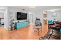 Living room featuring wood floors, large television, and adjacent kitchen view at 802 Antler Ct, Brandon, FL 33511