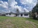 A single-story home featuring verdant lawn space, large windows, and a serene, cloud-filled sky overhead at 802 White Heron Blvd, Ruskin, FL 33570