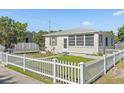 Well-maintained home featuring a white picket fence, green lawn, and cozy design at 918 27Th N St, St Petersburg, FL 33713