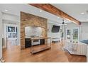 Bright living room featuring hardwood floors, brick accent wall, and stylish furniture at 1005 Main St, Safety Harbor, FL 34695