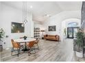 Open-concept living room features modern lighting, and wood-look floors at 10112 Downey Ln, Tampa, FL 33626