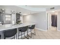 Kitchen with an island with seating and views into the hallway and doorways at 14401 Gulf Blvd # 106, Madeira Beach, FL 33708