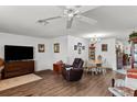 Bright and airy living area features hardwood floors, a ceiling fan, and views into the dining area at 1633 Bentwood Dr, Sun City Center, FL 33573