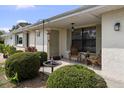 Inviting front porch with seating area and bird feeders, enhanced by lush green bushes and natural light at 1633 Bentwood Dr, Sun City Center, FL 33573