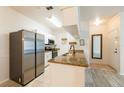 Bright kitchen featuring granite countertops, stainless steel refrigerator, white cabinets, and tile flooring at 16431 Enclave Village Dr # 16431, Tampa, FL 33647