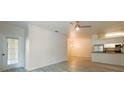 Open-concept living room with hardwood-style flooring, an adjacent kitchen and access to a screened balcony at 16431 Enclave Village Dr # 16431, Tampa, FL 33647