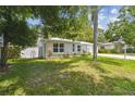 Charming home with lush green lawn, rock borders, flowering plants and a newer privacy fence at 1817 West Dr, Clearwater, FL 33755