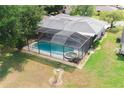 Aerial view of a home featuring a screened-in pool and spa, set in a large backyard at 1949 Tampa Bay Dr, Wesley Chapel, FL 33543