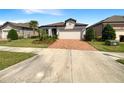 Attractive single-story home boasts a brick driveway, manicured lawn, and a serene neighborhood setting at 19664 Ship Wheel Way, Land O Lakes, FL 34638