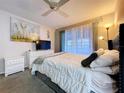 Cozy bedroom with a ceiling fan, large window with sheer curtains, and neutral decor at 2031 Dover Ct, Oldsmar, FL 34677