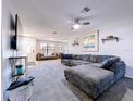 Spacious living room with plush carpeting, ceiling fan, and ample natural light from large windows at 2031 Dover Ct, Oldsmar, FL 34677