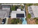 Aerial view of home, showcasing solar panels, fenced backyard, and colorful driveway at 2066 High Ridge Dr, Clearwater, FL 33763