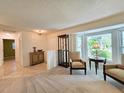 Bright living room with large windows, neutral carpet and comfortable furnishings at 3509 Oak Lake Dr, Palm Harbor, FL 34684