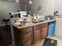 Kitchen with sink, cabinets, granite countertops and blue dishwasher at 3512 16Th E St, Bradenton, FL 34208