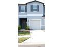 Townhome exterior features a concrete driveway leading to an attached garage at 36439 Garden Wall Way, Zephyrhills, FL 33541