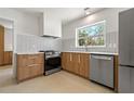 Modern kitchen featuring stainless steel appliances, white backsplash, and sleek wooden cabinetry at 433 Pineapple St, Tarpon Springs, FL 34689