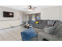 Inviting living room with tile floors, a cozy sectional sofa, and sliding doors for natural light at 4813 Glenaire Ct, Tampa, FL 33624