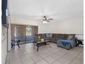 Spacious living room featuring tile floors, comfortable sectional seating, and a sliding glass door at 4813 Glenaire Ct, Tampa, FL 33624