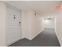 Condo hallway with gray carpet and a white door with unit number at 6265 Sun Blvd # 1203, St Petersburg, FL 33715