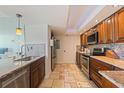 Well lit kitchen with stainless appliances, stone floors and granite countertops at 6265 Sun Blvd # 1203, St Petersburg, FL 33715