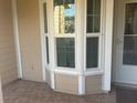 Charming bay window providing natural light and character to the space with tile floor and neutral siding at 6520 Thicket Trl, New Port Richey, FL 34653